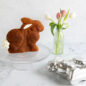 Baked Bunny Cake on cake stand next to vase of Tulips and 3D Bunny Cake Pan