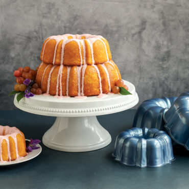 tiered baked cakes with glaze, on pedestal, grapes around cake, 3 cup Bundt® cake plated, with pans