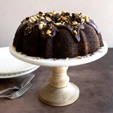 Chocolate Bundt® Cake with chocolate frosting, sprinkled with nuts and chocolate shavings