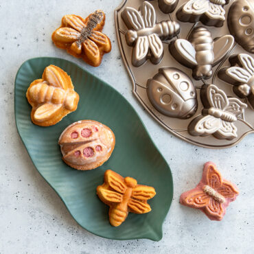 Backyard Bugs Cakes, some decorated, overhead on leaf plate with pan