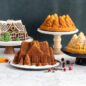 Pine Forest Bundt Cakes on stands with Gingerbread House Bundt cakes.