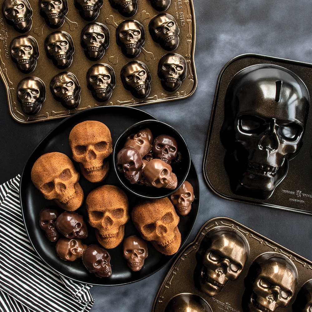 Image of Nordic Ware's Skull Bakeware Collection with plate of baked cakes and chocolates