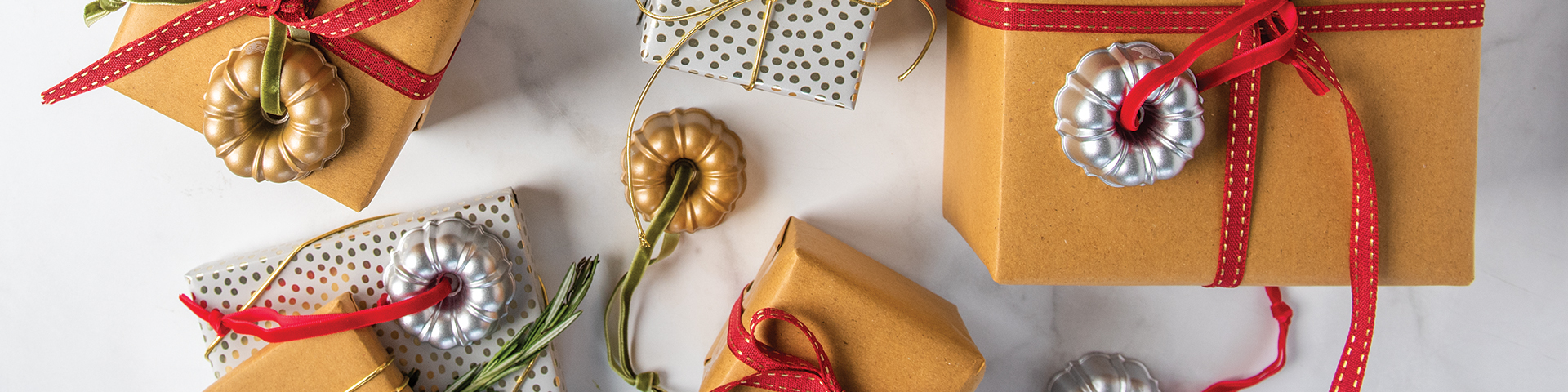 Image of wrapped gifts with ornaments tied to the top of the boxes