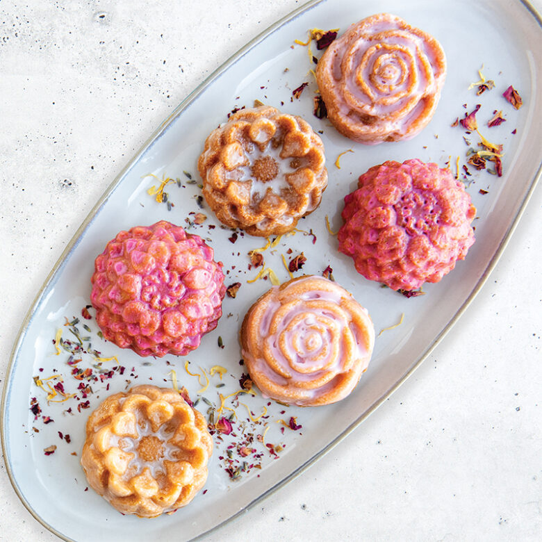 Overhead image lemon floral cakelets with pink and purple hue glazes on platter