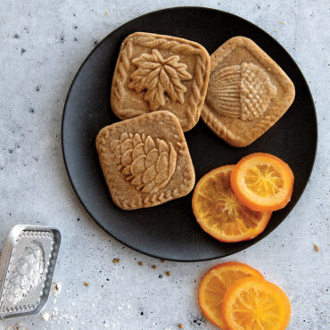 Fall Forest Springerle Stamped Cookies on black plate with orange slices