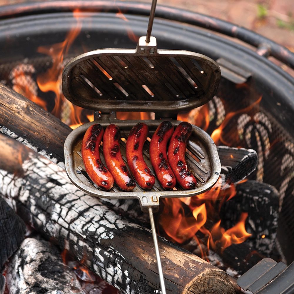 Image of cooked hot dogs in Nordic Ware's Campfire Griller over a campfire