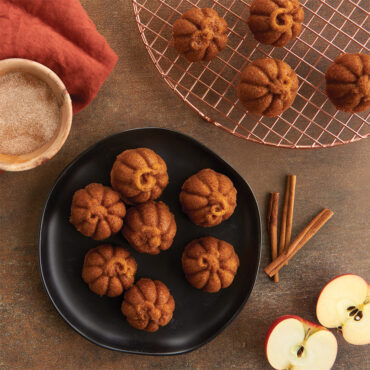 Lil' Pumpkin Cakelets on plate, copper round cooling grid, apples and cinnamon sticks