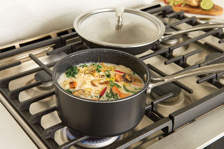 Stovetop scene with Basalt Ceramic Sauce Pan with curry and vegetables and small saute pan with lid in background