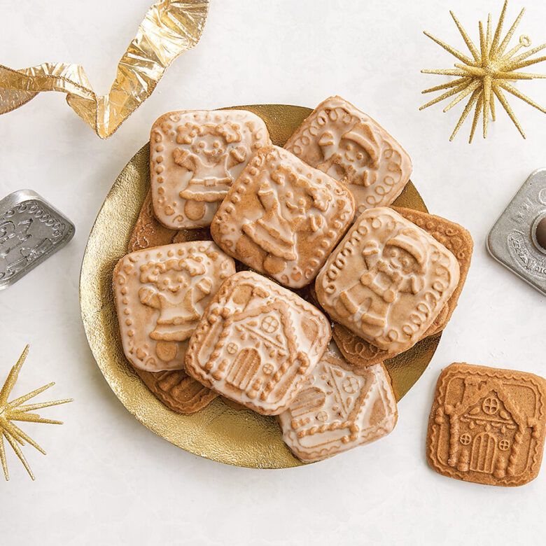 Overhead image baked glazed gingerbread stamped cookies in detailed gingerbread designs