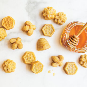 Baked bee bites on marble background with honey jar