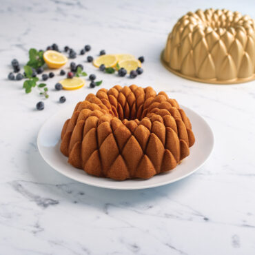 Kaleidoscope Bundt Cake with Blueberries, lemon slices, and pan in the background