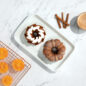 Classic Bundt Duet Cakes, plated, with bowl of cinnamon and cooling rack with orange slices