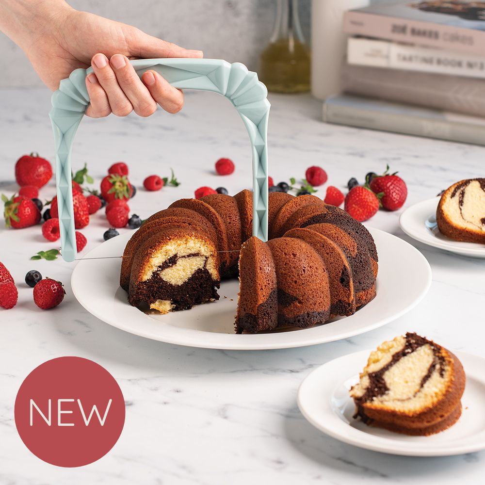 Image of baked Bundt on a platter with a hand using the Bundt slicer to cut pieces of the cake onto plates